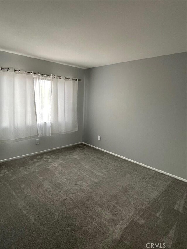 unfurnished room with carpet floors and baseboards