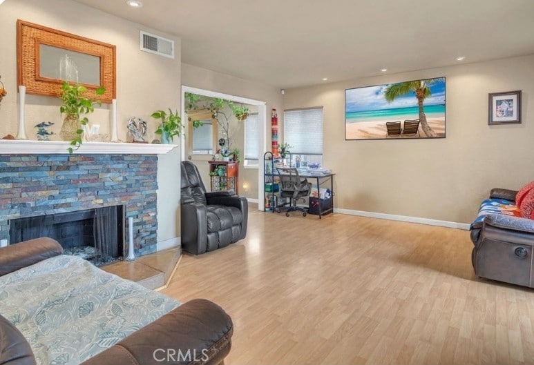 living room featuring baseboards, recessed lighting, visible vents, and wood finished floors