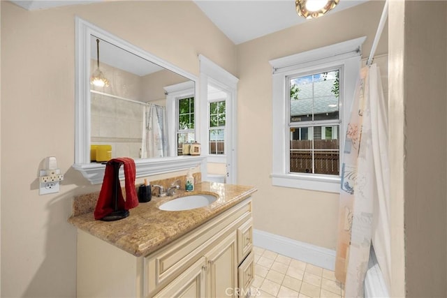 bathroom with plenty of natural light, baseboards, tile patterned floors, and vanity