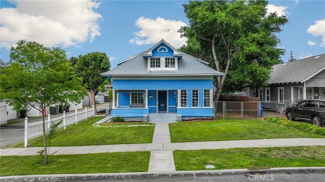 view of front of home with fence, covered porch, and a front yard
