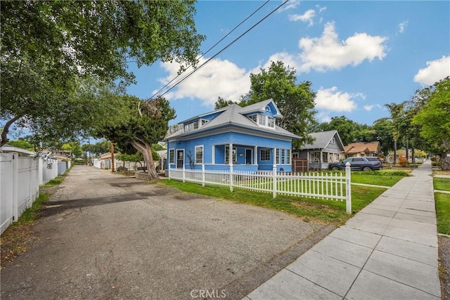 view of front of home with a fenced front yard, covered porch, and a front yard