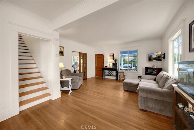 living room with plenty of natural light, stairs, and wood finished floors