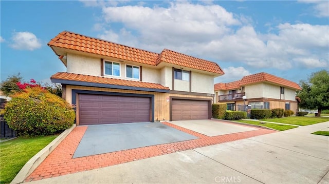 view of front of property featuring a front yard, an attached garage, and driveway