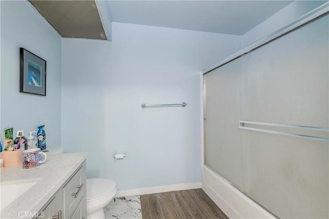 full bathroom with toilet, baseboards, vanity, and bath / shower combo with glass door