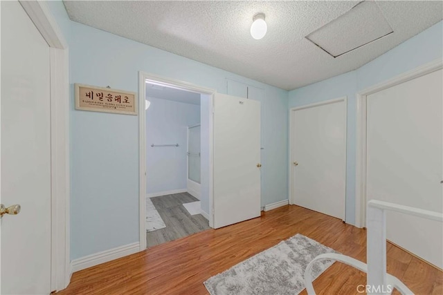 unfurnished bedroom with a textured ceiling and wood finished floors