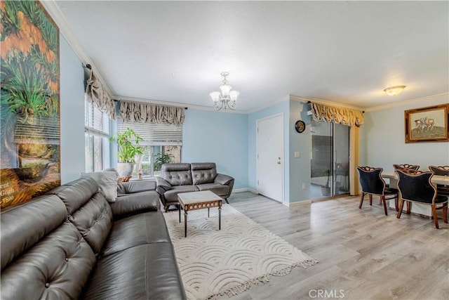living area with an inviting chandelier, crown molding, baseboards, and light wood-type flooring