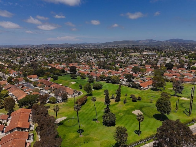 birds eye view of property with view of golf course, a mountain view, and a residential view