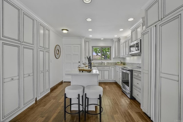 kitchen featuring light countertops, stainless steel appliances, dark wood finished floors, and a kitchen island
