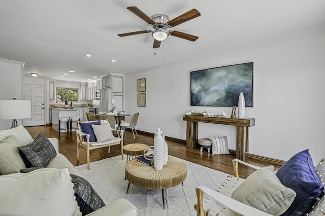 living area with baseboards, recessed lighting, a ceiling fan, and wood finished floors