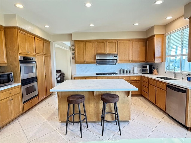 12271 Oldenberg Ct, Rancho Cucamonga, CA 91739 - kitchen featuring stainless steel appliances, a sink, a center island, a breakfast bar, and under cabinet range hood