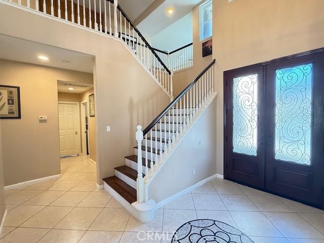 12271 Oldenberg Ct, Rancho Cucamonga, CA 91739 - tiled entryway with french doors, stairway, healthy amount of natural light, a high ceiling, and recessed lighting