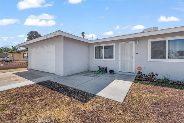 single story home with concrete driveway, stucco siding, and an attached garage