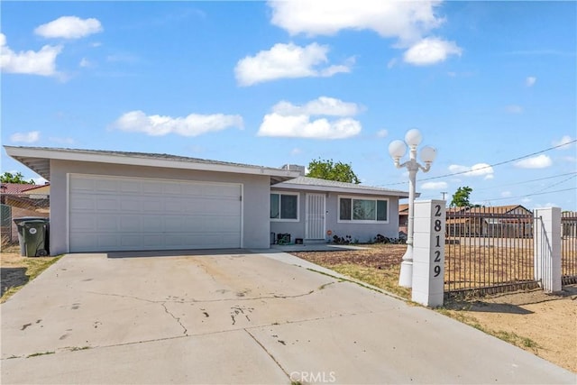 ranch-style house featuring fence private yard, a garage, stucco siding, and driveway
