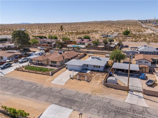 drone / aerial view with a desert view, a mountain view, and a residential view