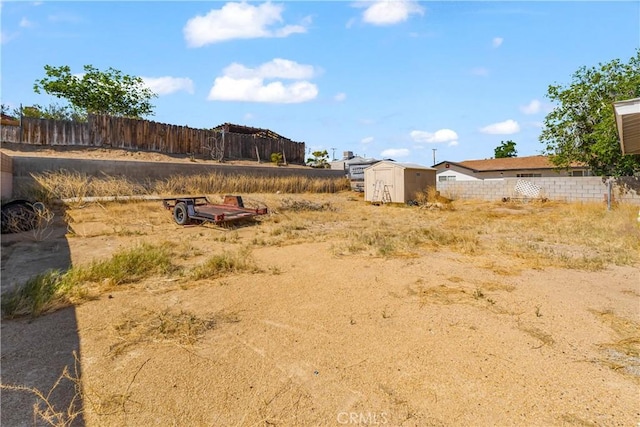 view of yard with an outdoor structure, a shed, and fence