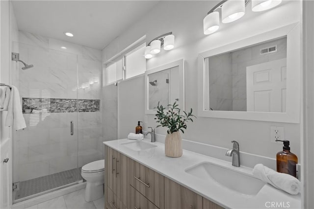 bathroom with toilet, a sink, marble finish floor, and a stall shower