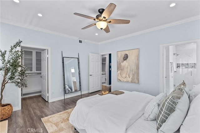 bedroom featuring visible vents, crown molding, a walk in closet, and wood finished floors