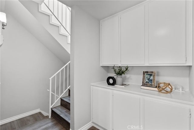 staircase with baseboards and wood finished floors