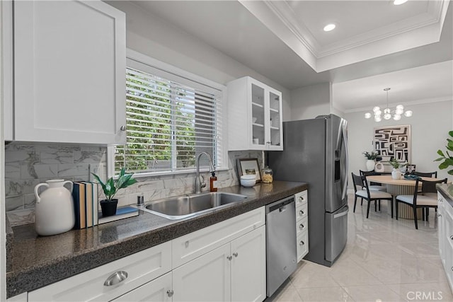 kitchen with decorative backsplash, glass insert cabinets, white cabinets, a sink, and appliances with stainless steel finishes