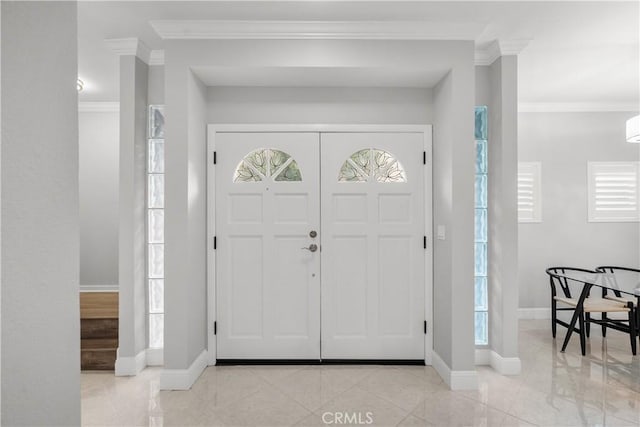 foyer featuring crown molding, baseboards, and a wealth of natural light