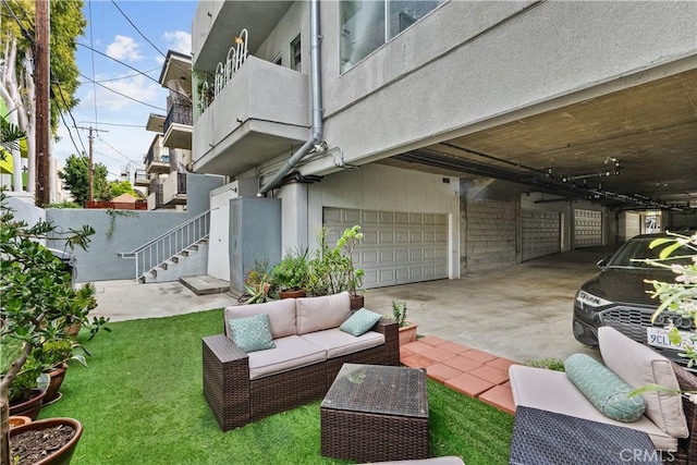 exterior space featuring an attached garage, an outdoor living space, and driveway