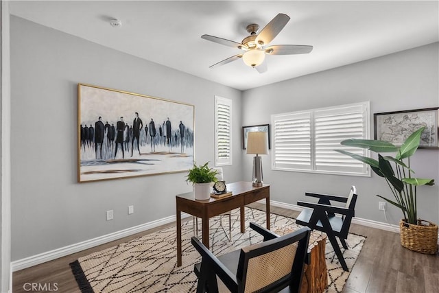 office featuring baseboards, a ceiling fan, and wood finished floors