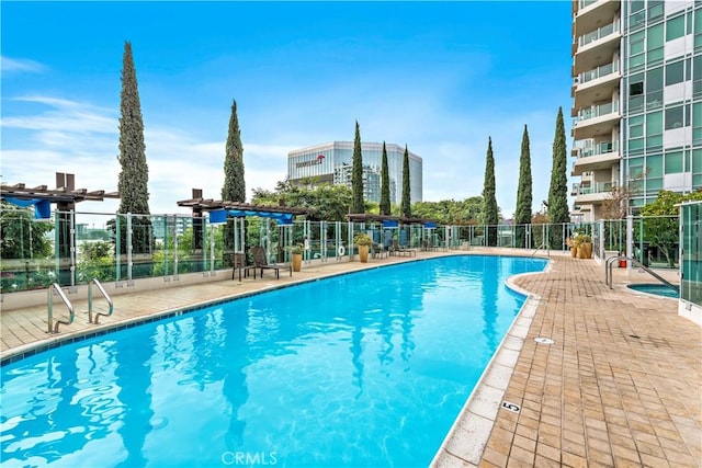 pool featuring fence and a patio