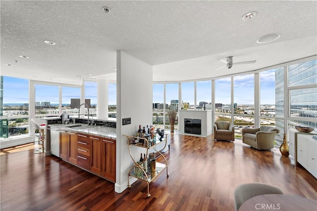 kitchen featuring a view of city, a sink, a textured ceiling, and brown cabinets