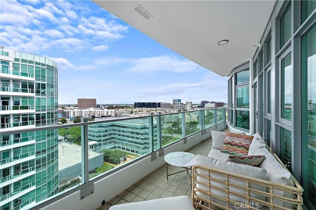 balcony featuring a view of city, an outdoor living space, and visible vents