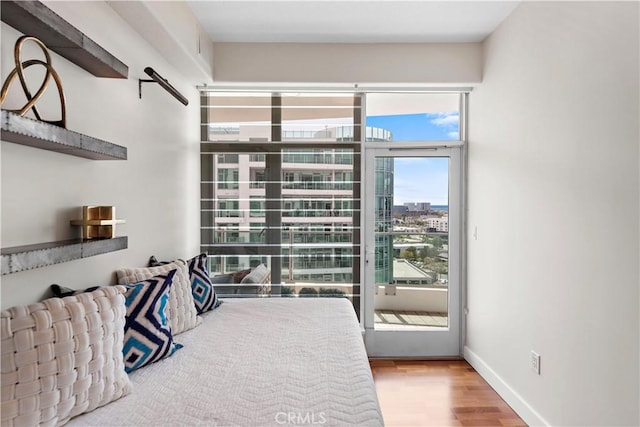 bedroom featuring a city view and wood finished floors