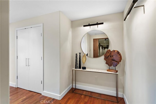 hallway with baseboards and wood finished floors