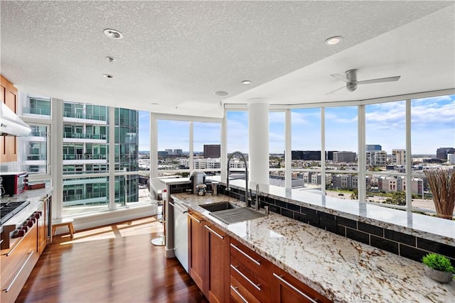 kitchen with dark wood finished floors, a sink, a textured ceiling, and a city view