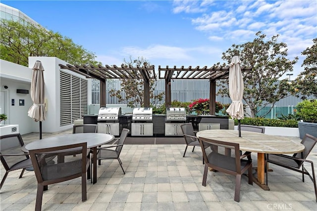 view of patio with outdoor dining area, exterior kitchen, and a pergola