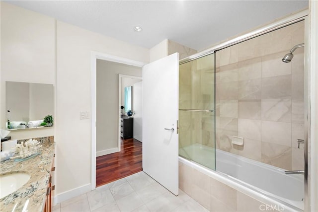 bathroom featuring tiled shower / bath combo, baseboards, and vanity