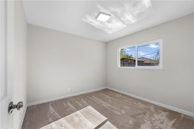 unfurnished room with baseboards and carpet flooring
