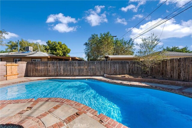 view of swimming pool featuring a fenced in pool, a fenced backyard, and central air condition unit