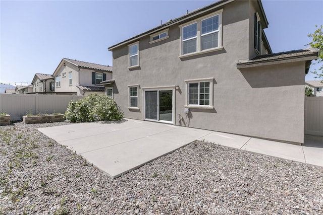 27488 Ginger Ct, Saugus, CA 91350 - back of house featuring a patio, a residential view, stucco siding, fence, and a garden