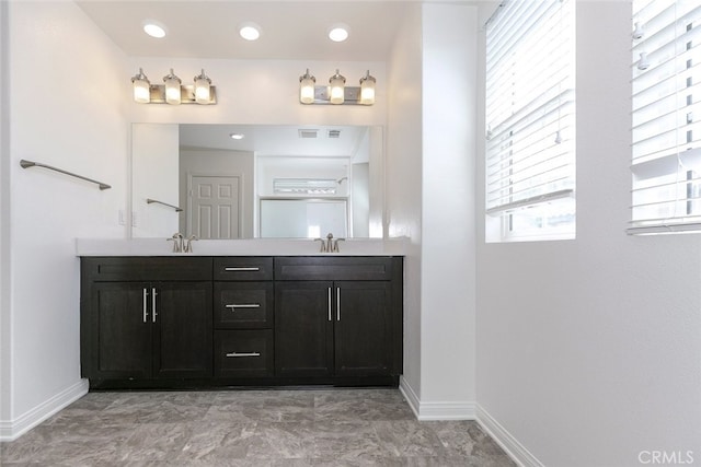 27488 Ginger Ct, Saugus, CA 91350 - bathroom featuring double vanity, marble finish floor, baseboards, and a sink