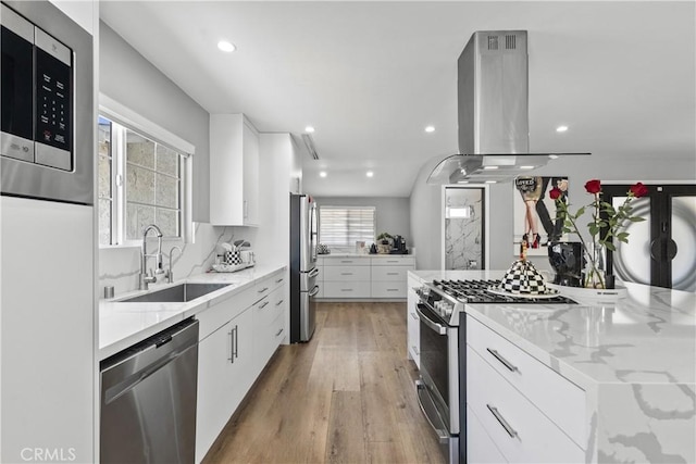 17321 Lahey St, Granada Hills, CA 91344 - kitchen with island range hood, appliances with stainless steel finishes, modern cabinets, a sink, and white cabinets