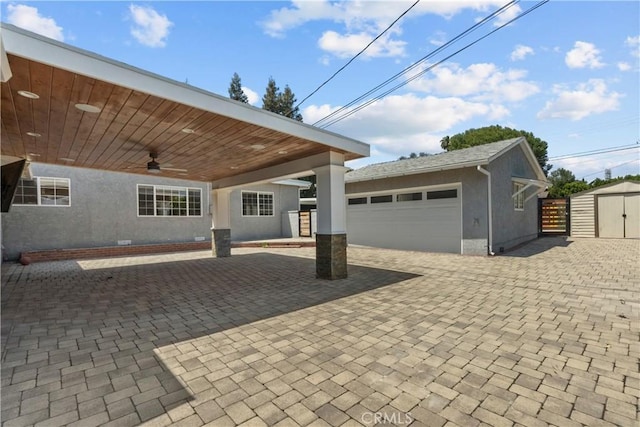 17321 Lahey St, Granada Hills, CA 91344 - view of front of house with an outdoor structure, a garage, ceiling fan, stucco siding, and a storage unit