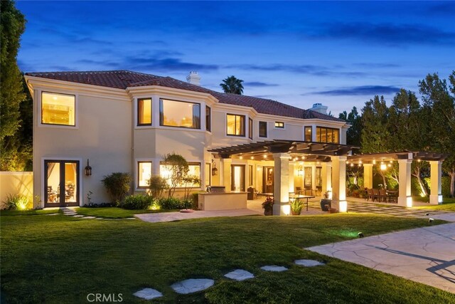 back of property featuring a yard, a pergola, french doors, and a chimney