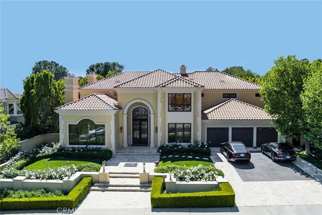 view of front of property featuring a garage, stucco siding, a tiled roof, and a chimney