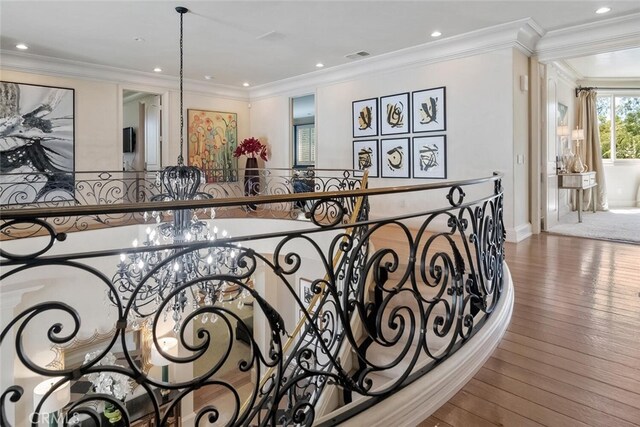 interior details with visible vents, ornamental molding, wood finished floors, and a notable chandelier
