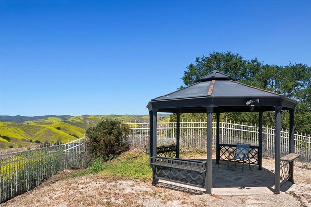 surrounding community featuring a gazebo, a mountain view, and a fenced backyard