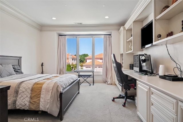 bedroom with crown molding, visible vents, light carpet, and built in desk