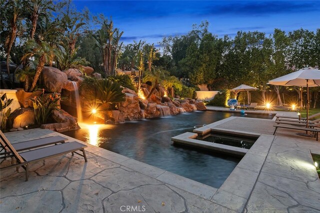 outdoor pool with a patio and an in ground hot tub
