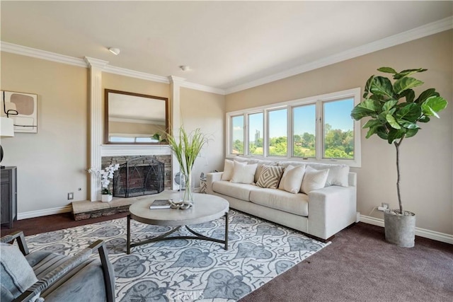 living room featuring baseboards, ornamental molding, a stone fireplace, and dark colored carpet