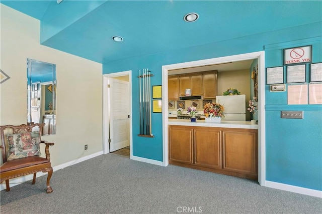 interior space with baseboards, freestanding refrigerator, recessed lighting, and light carpet