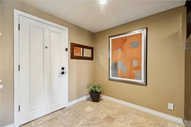 entryway featuring baseboards and stone finish floor