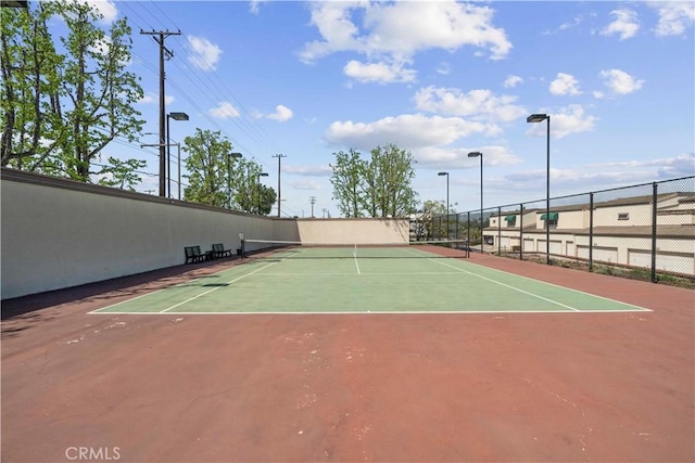view of tennis court with fence and community basketball court